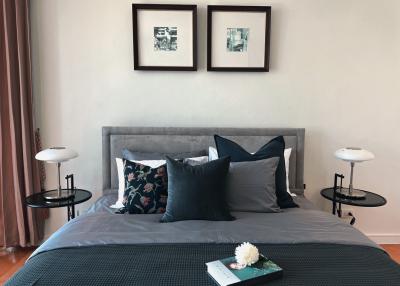 Modern bedroom with neatly arranged pillows on bed and framed artwork