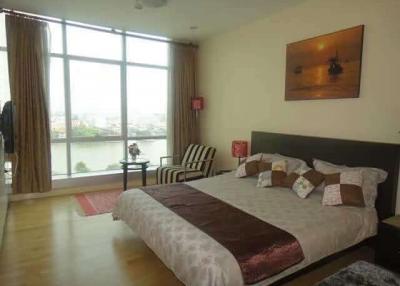 Spacious bedroom with large windows and waterfront view