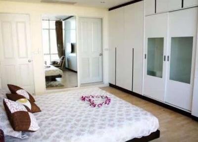Spacious bedroom with large bed and modern wardrobe
