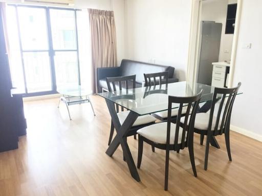 Modern dining area with glass table and balcony access