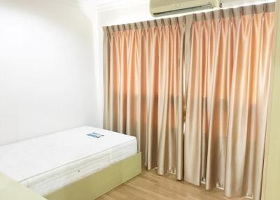 Bright and clean bedroom with a single bed and air conditioning unit
