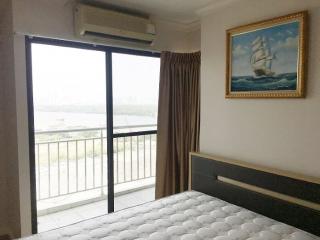 Spacious bedroom with a scenic river view and balcony access