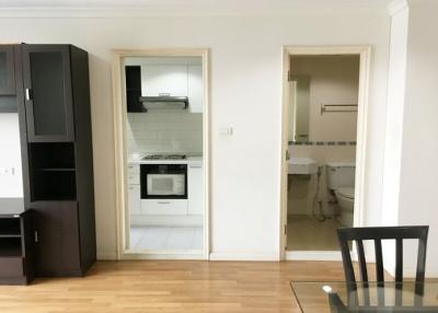 Compact apartment interior with an open doorway to the kitchen and visible entrance to the bathroom