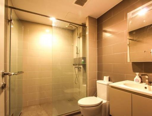 Modern bathroom with glass shower and well-lit vanity area