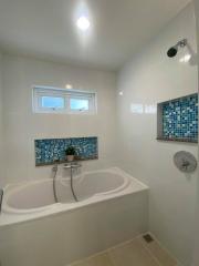 Modern bathroom interior with bathtub and tiled accents