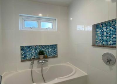 Modern bathroom interior with bathtub and tiled accents