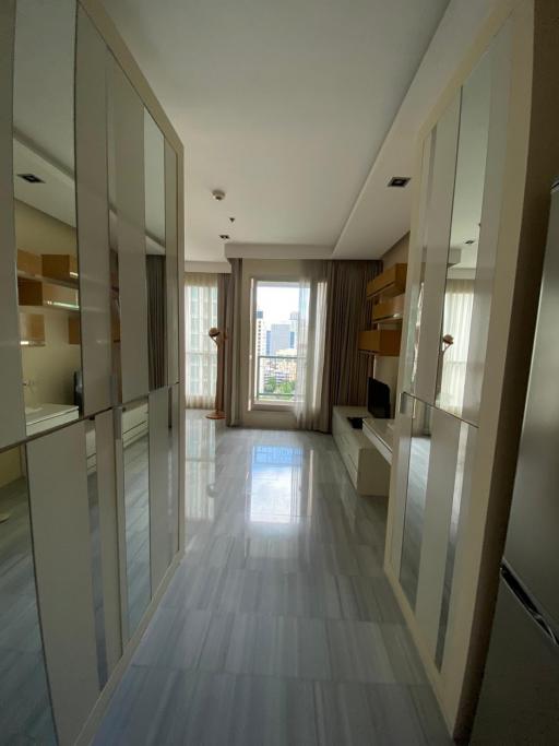 Bright and spacious hallway with floor-to-ceiling mirrors and tiled flooring