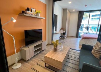 Cozy and modernly furnished living room with warm orange walls and ample natural light