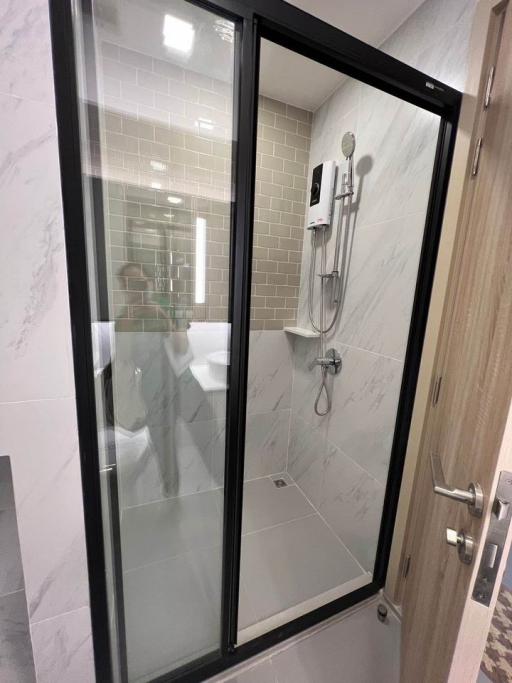 Modern bathroom with glass shower enclosure and marble tiling