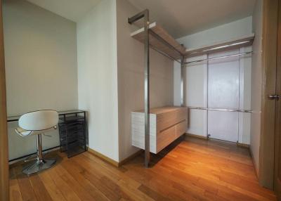 Compact bedroom with wooden flooring, loft bed, and built-in wardrobe