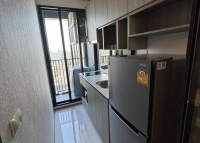 Modern compact kitchen with stainless steel appliances and balcony access