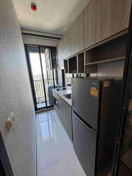 Modern compact kitchen with stainless steel appliances and balcony access