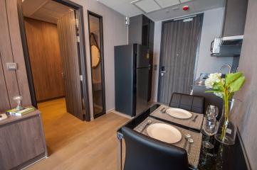 Modern kitchen with dining area, stainless steel appliances, and wooden cabinetry