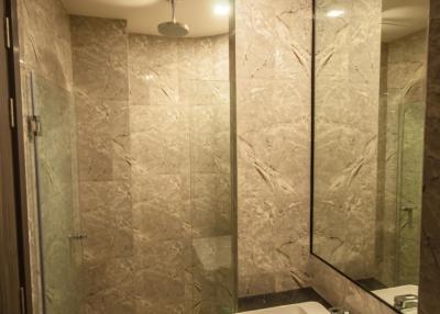 Modern bathroom with beige tiles and glass shower