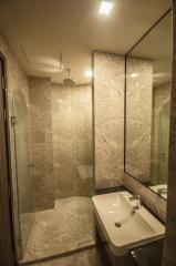 Modern bathroom with beige tiles and glass shower