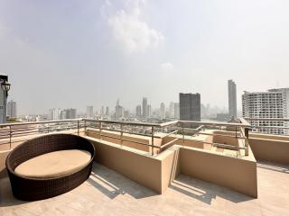 Spacious balcony with city view and outdoor seating