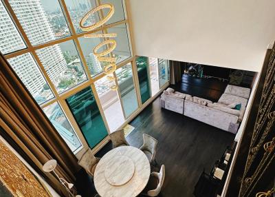 Spacious two-story living room with large windows and modern furniture