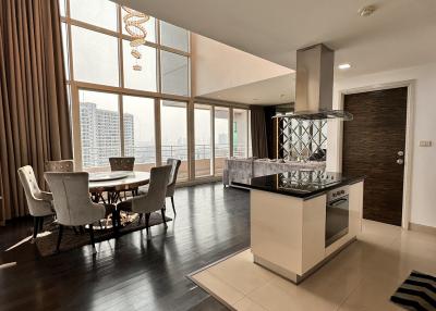 Spacious apartment interior with open plan dining and kitchen area, large windows, and modern design