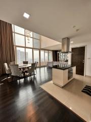 Spacious apartment interior with open plan dining and kitchen area, large windows, and modern design