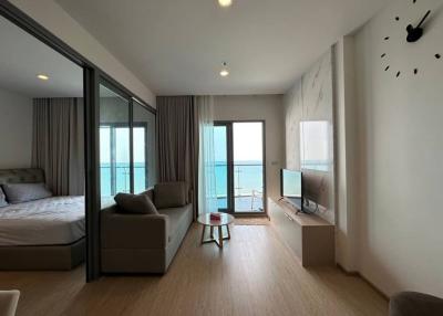 Spacious bedroom with modern design, large glass doors, and ocean view