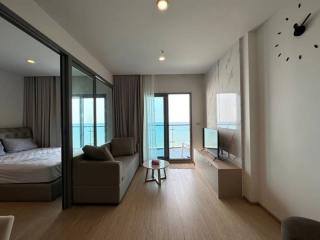 Spacious bedroom with modern design, large glass doors, and ocean view