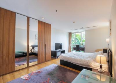 Spacious bedroom with large bed and mirrored wardrobe