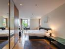 Modern bedroom interior with a large bed, mirrored wardrobe, and hardwood floors