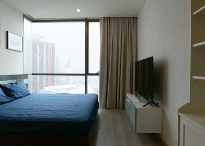 Spacious and modern bedroom with floor-to-ceiling window and city view