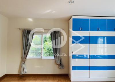 Bright bedroom with blue and white wardrobe and large window