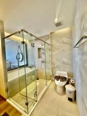 Modern bathroom with glass shower enclosure and marble tiles