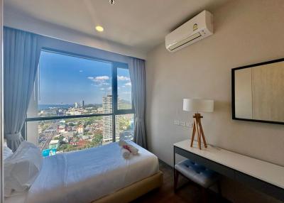 Modern bedroom with a large window offering a city view