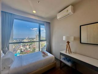 Modern bedroom with a large window offering a city view