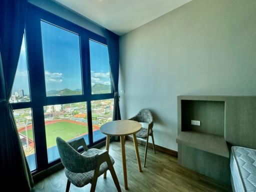 Modern bedroom with a view, featuring a round table and comfortable seating