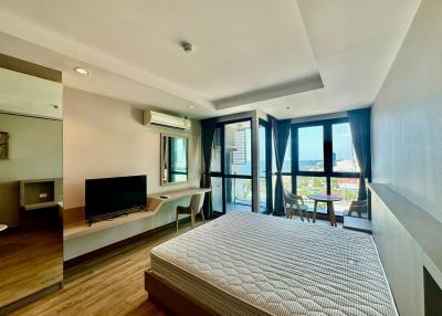 Spacious and well-lit bedroom with modern furnishings and balcony access