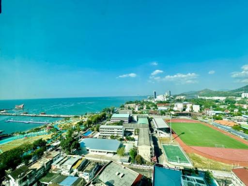 Expansive aerial view of a coastal area with urban landscape and blue sea under a clear sky