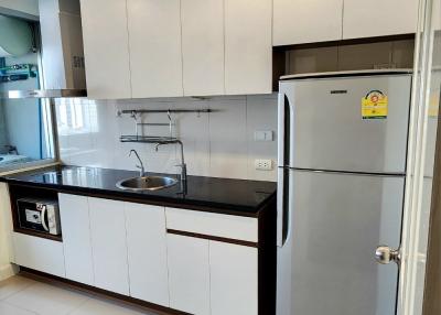 Modern kitchen with wooden accents and full-sized refrigerator
