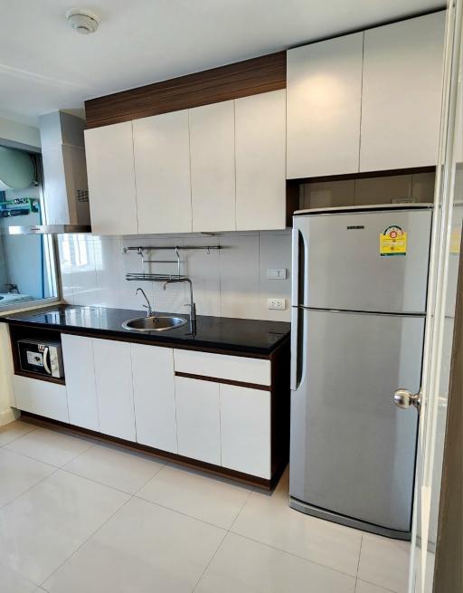 Modern kitchen with wooden accents and full-sized refrigerator