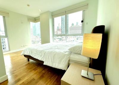 Spacious and well-lit bedroom with a city view