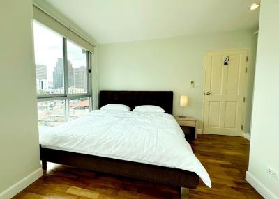 Spacious bedroom with a large bed and city view