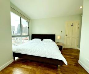 Spacious bedroom with a large bed and city view