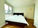 Spacious bedroom with a large bed and city view