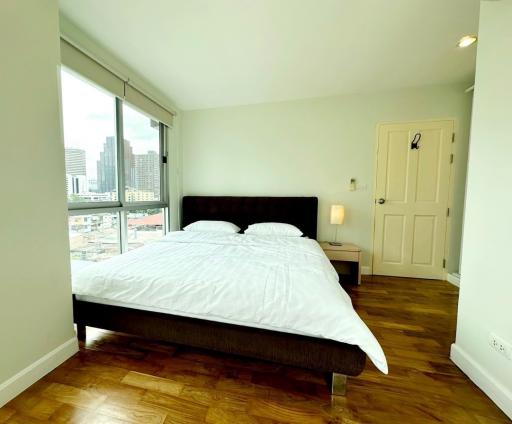 Spacious bedroom with a large bed and city view