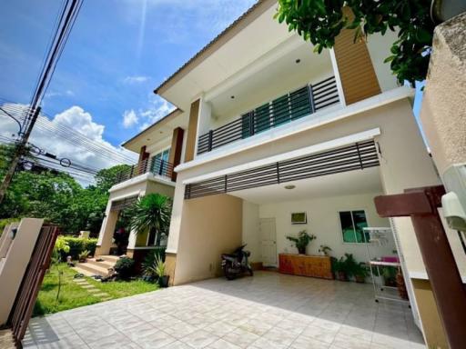 Bright and spacious two-story house with a large driveway and beautiful greenery