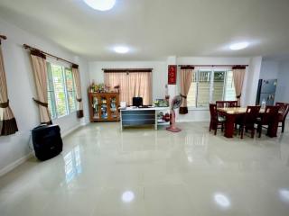 Spacious and well-lit living room with glossy tiled flooring, large windows, and modern furnishings