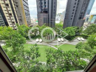 Lush green garden view with modern high-rise buildings in the background