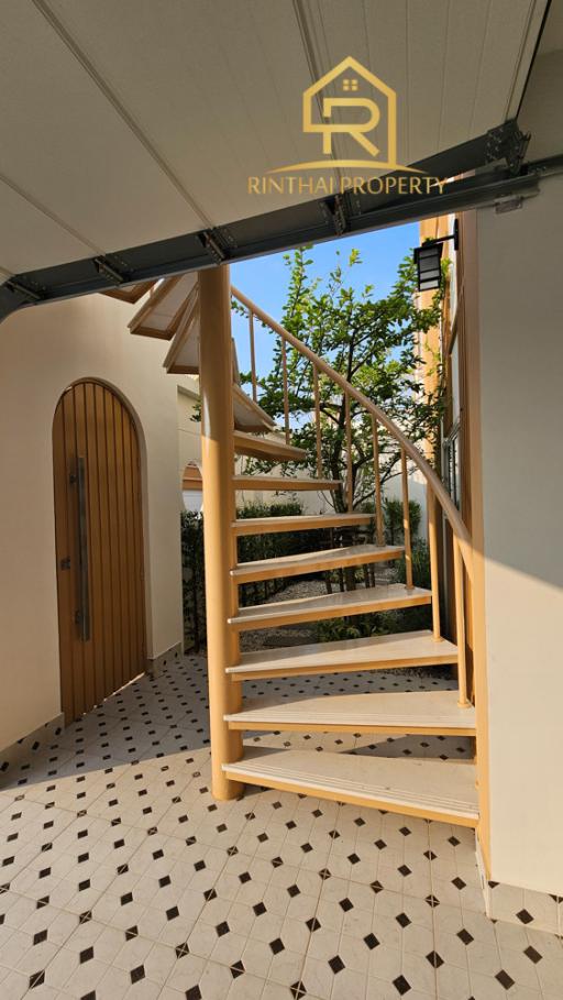 Elegant exterior staircase leading to an upper floor with tasteful wooden details and tile flooring