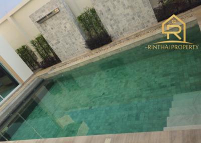 Private swimming pool in residential backyard with surrounding patio and garden