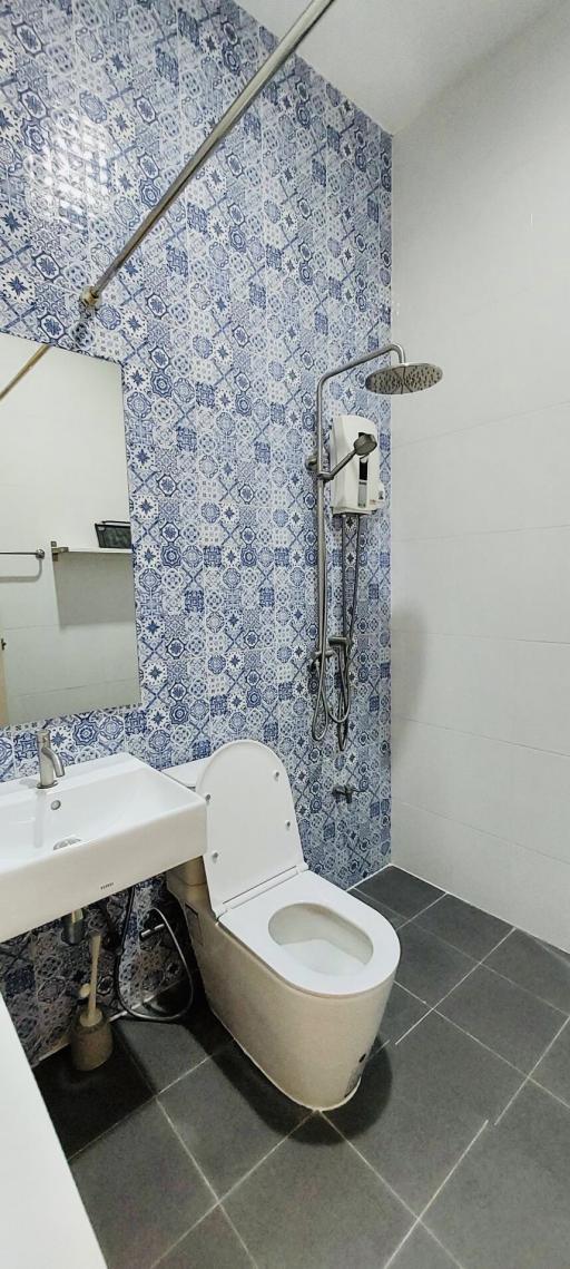 Modern bathroom with decorative tiled wall and gray flooring