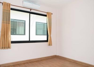 Spacious bedroom with large window and air conditioning