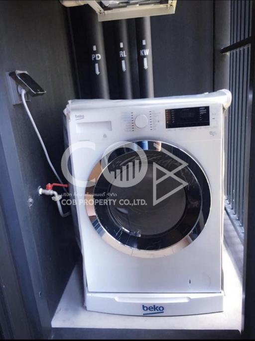 Compact laundry room with modern washing machine and built-in shelving